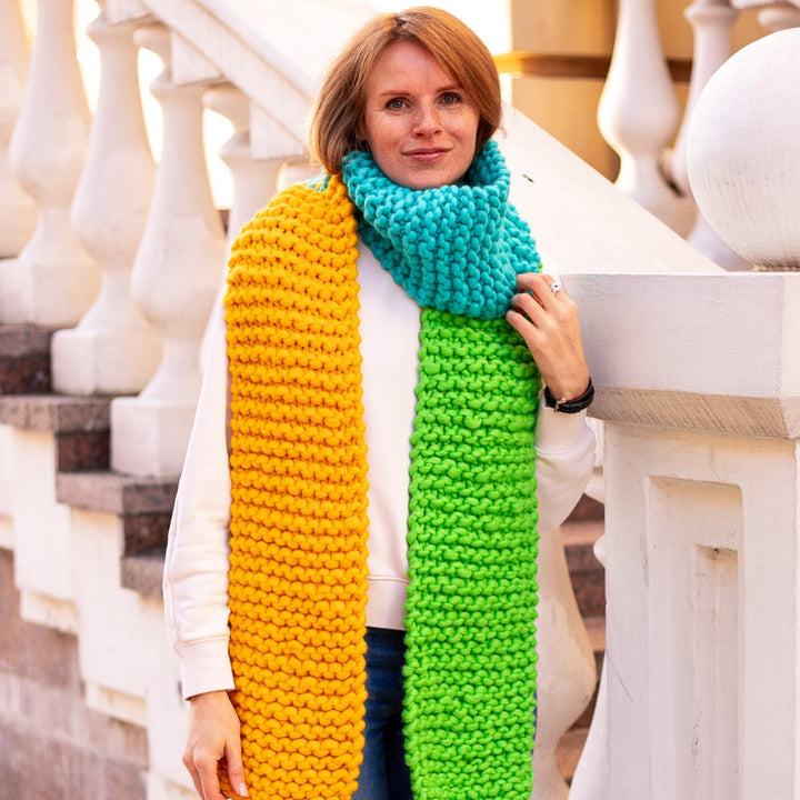 Person wearing a colorful scarf standing on a staircase